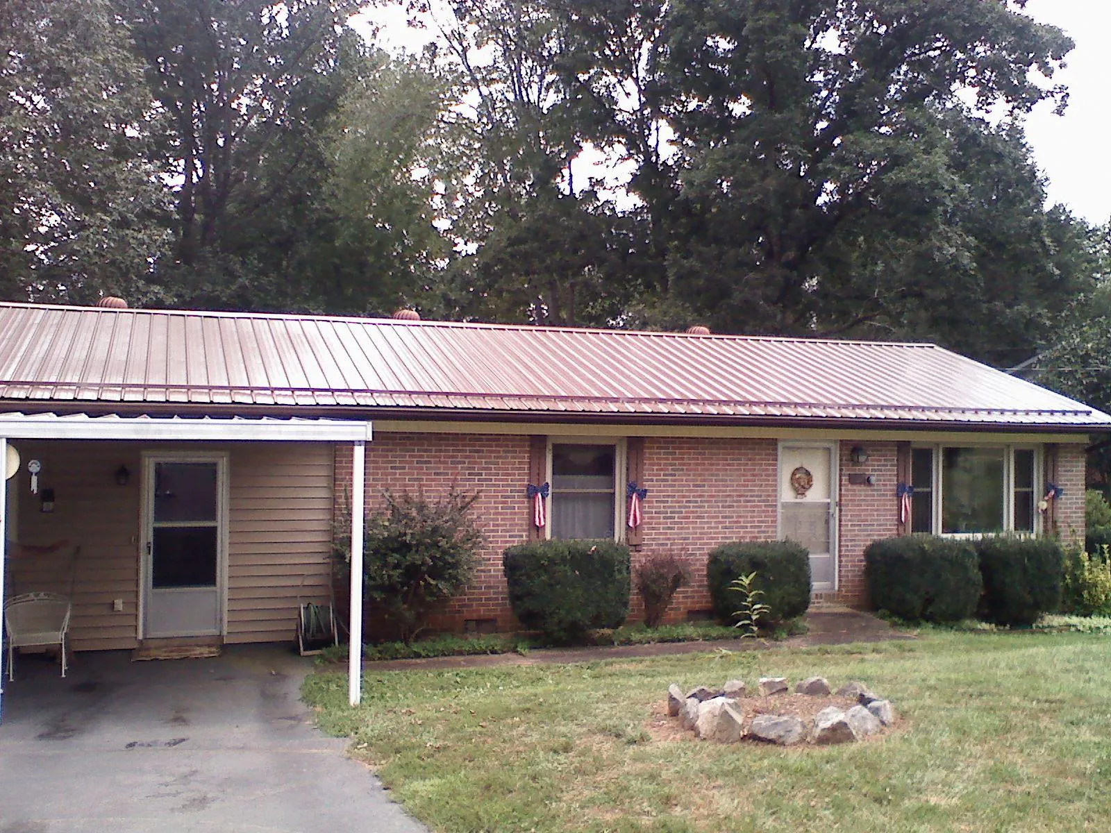 Bronze metal roof and carport on a brick ranch home — Roof Repair work by our crew in Bow